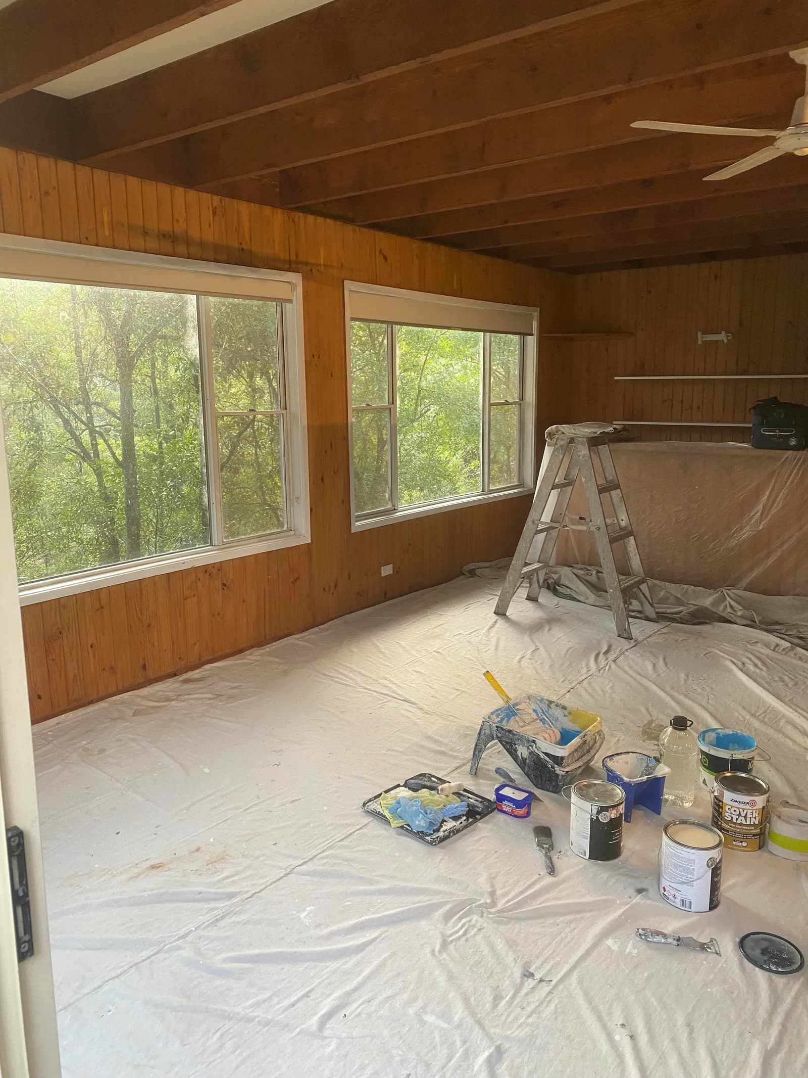 Cabinetry wrapped in plastic and floors sheeted before interior painting on a real Award Painting job