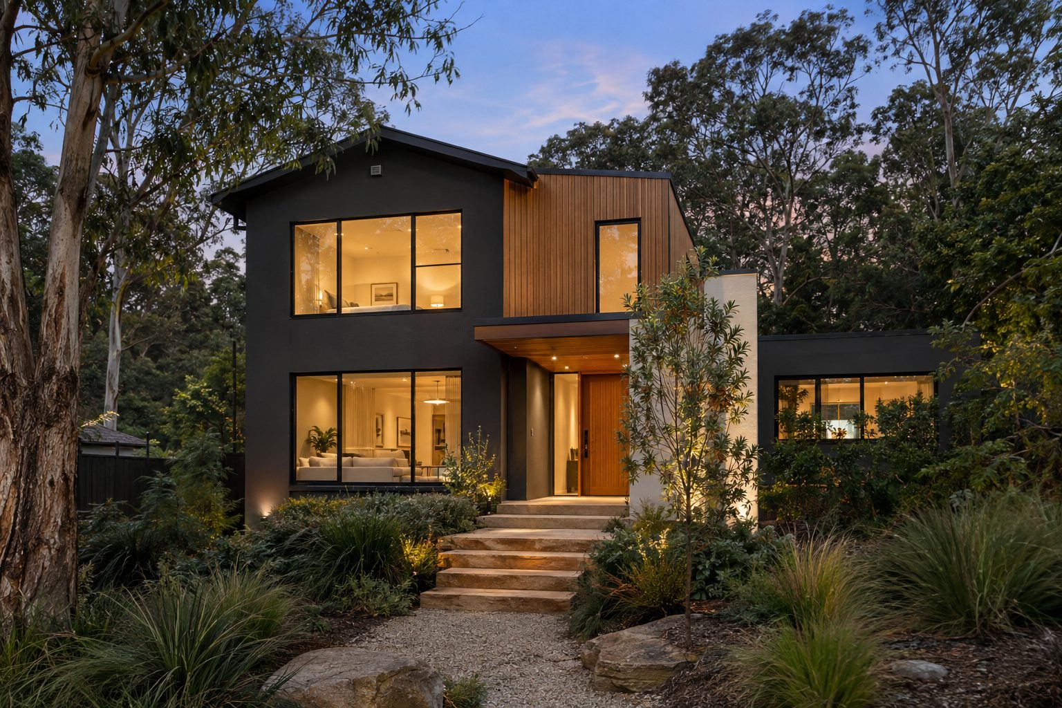 Contemporary rendered home in Turramurra at dusk surrounded by gum trees