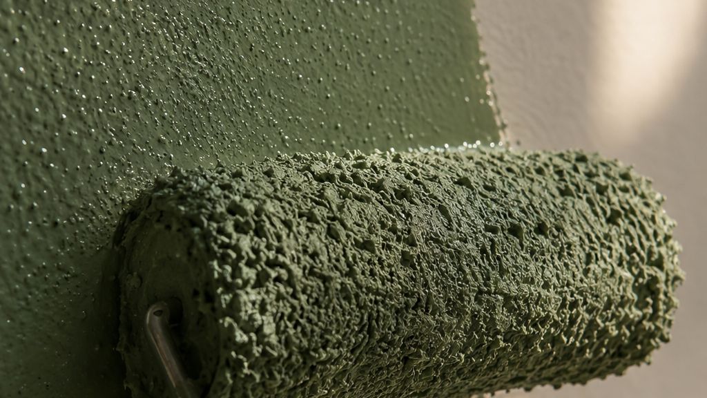 Close-up of a roller laying down warm white paint